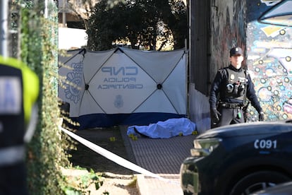 Un agente de la Policía Nacional junto al cuerpo del hombre asesinado la mañana de este martes en Alcalá de Henares.