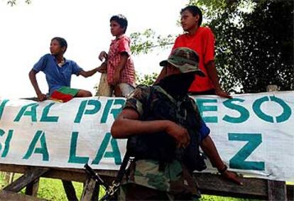 Un miembro de las AUC hacía guardia ayer ante un grupo de niños en la carretera de acceso a Santa Fe de Ralito.