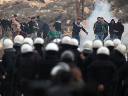 Jovenes palestinos del campo de refugiados de al-Jalazoun se enfrentan a la polic&iacute;a palestina en el bloqueo de una carretera.