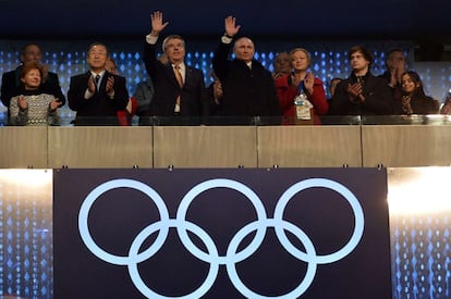 O presidente russo, Vladimir Putin (centro) e o presidente do Comitê Olímpico Internacional, Thomas Bach, saúdam o público.