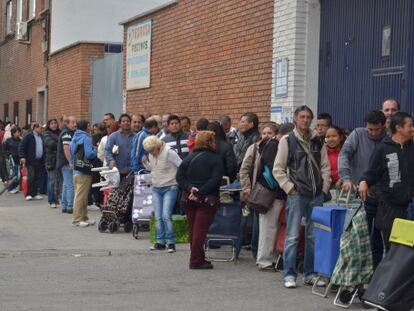 Algunas Familias de Vallecas hacen cola a la espera de alimentos.