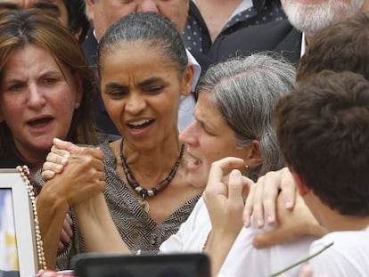 Marina segura na m&atilde;o de Renata na missa p&uacute;blica de Eduardo Campos.