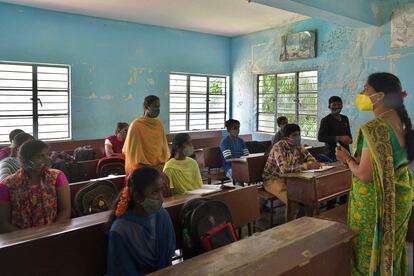 Los estudiantes de una escuela pública asisten a su clase el primer día de reapertura para los cursos de secundaria con una capacidad del 50% después de 18 meses de cierre debido a la pandemia del coronavirus en Bangalore el 23 de agosto de 2021.