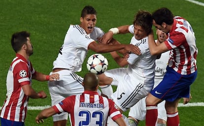 Varane, Fabio Coentrao, del Real Madrid, pelean por el bal&oacute;n presionados por tres jugadores del Atl&eacute;tico. 