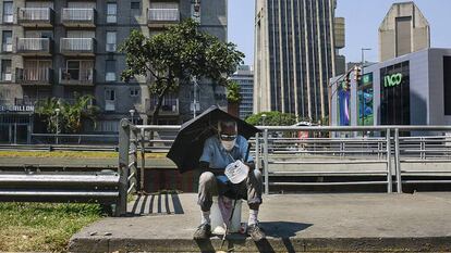 Un hombre pide limosna sentado en la avenida Libertador de Caracas. / ANDREA HERNÁNDEZ