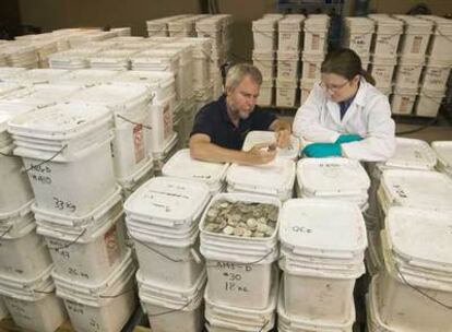 El cofundador de Odyssey, Greg Stemm (a la izquierda), examina monedas recuperadas del pecio del <b><i>Cisne Negro </b></i>el pasado mayo.