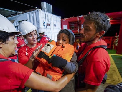 Trabalhadores de Save the Children ajudam uma criança que saiu da costa da Líbia em direção à Europa.