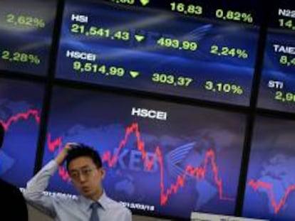 Corredores de bolsa conversan junto a una pantalla que muestra información bursátil en Seúl (Corea del Sur). EFE/Archivo