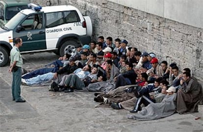 Un grupo de inmigrantes espera en el puerto de Tarifa su traslado a la Isla de las Palomas.