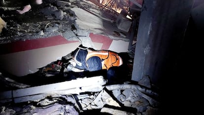 Un miembro de la Defensa Civil Palestina busca supervivientes entre los escombros de un edificio bombardeado por el ejército israelí, este lunes en Rafah. 