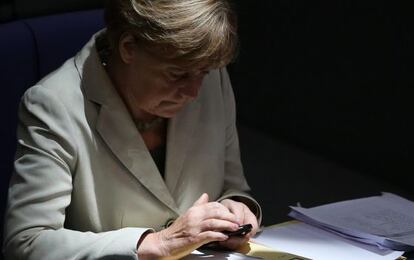 Angela Merkel consulta su m&oacute;vil durante un debate sobre el presupuesto federal de 2015 en el Bundestag
