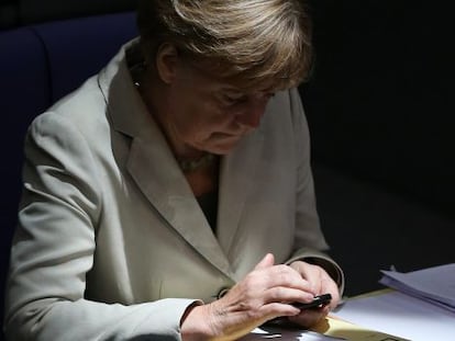 Angela Merkel consulta su m&oacute;vil durante un debate sobre el presupuesto federal de 2015 en el Bundestag