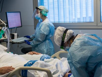 Personal sanitario atendiendo a un paciente ingresado en la UCI para enfermos de coronavirus del Hospital Trueta (Girona)