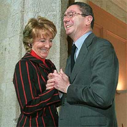 Esperanza Aguirre y Alberto Ruiz-Gallardón se saludan sonrientes durante el acto de ayer.