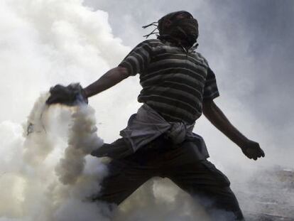 Un manifestante lanza gas lacrimógeno en Tahrir.
