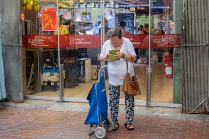 Una mujer revisa su monedero a la salida del mercado de Hostafrancs, en Barcelona.