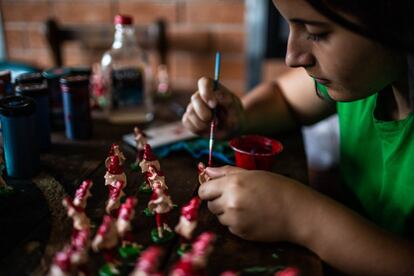 Camila Benavides, de 21 años, una de las cuatro hijas de Erika. Trabaja pintando figuras para los belenes de Navidad, y por cada una gana menos de cinco céntimos de euro. Este es uno de los oficios que alterna con el de la reparación de calzado, junto a su esposo. Alquila una casa donde paga cerca 85 euros en el barrio La Sirena.