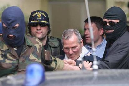 Bernardo Provenzano, escoltado por varios policías, llega ayer al edificio en Palermo donde ha quedado detenido.