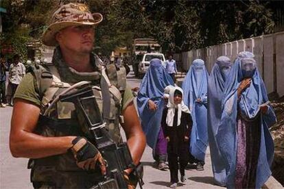 Un soldado español, junto a un grupo de mujeres afganas ataviadas con <i>burka,</i> en Kabul en julio de 2004.