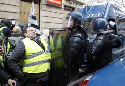 Policías antidisturbios impiden que un manifestante acceda a una calle de París durante la jornada de protesta.