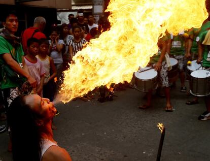 Un tragafuegos actúa en una de las calles del barrio Chinatown de Manila (Filipinas).