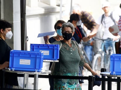 Una mujer deposita su voto para el referéndum este domingo en una mesa de votación en Zúrich.