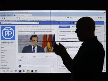 Un hombre frente a una pantalla con la página de Facebook del Partido Popular.