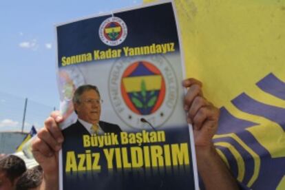 Un seguidor del Fenerbahçe muestra un cartel con una foto de Yilidrim en que se lee “Gran presidente, estaremos juntos hasta el final”.