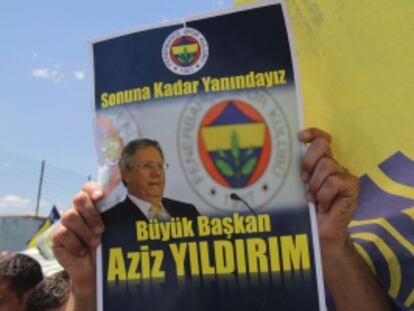 Un seguidor del Fenerbahçe muestra un cartel con una foto de Yilidrim en que se lee “Gran presidente, estaremos juntos hasta el final”.