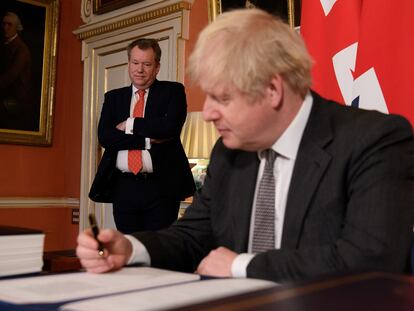 Boris Johnson firma, ante su negociador con la UE, David Frost, el Acuerdo Comercial, el 30 de diciembre
