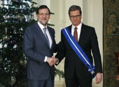 El presidente del Gobierno, Mariano Rajoy (i), estrecha la mano al ministro de Asuntos Exteriores de Alemania, Guido Westerwelle, tras imponerle hoy la Gran Cruz de la Orden del Mérito Civil en un acto celebrado en el Palacio de la Moncloa.