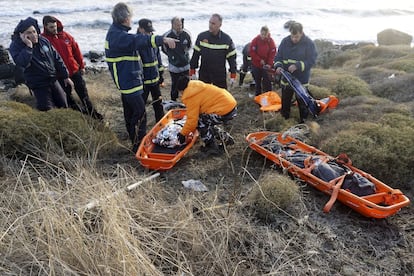 Los bomberos griegos depositan dos cuerpos en unas camillas en la orilla de la isla griega de Lesbos, el 25 de octubre de 2015.