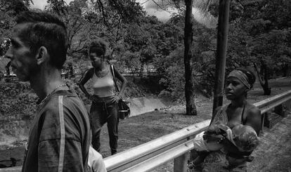 Una familia recolecta agua de un cauce en Caracas.