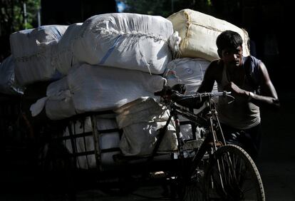 Un trabajador carga sacos en su bicicleta en Calcuta (India). 