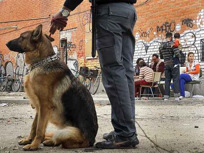 Un guarda jurado vigila una zona de la cárcel de Carabanchel, junto a un grupo de rumanos que vive en la prisión.