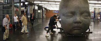Antonio López, en primer plano a la izquierda,  dirige la instalación de las esculturas en la estación de Atocha.