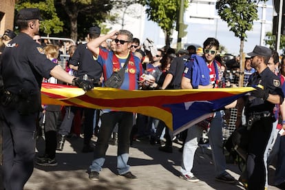 La policía sujeta una bandera estelada de unos aficionados del Barcelona.