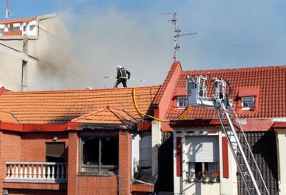 Un bombero trabaja en el tejado afectado por las llamas en la Alameda de Rekalde.