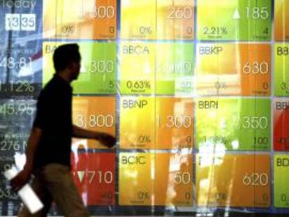 Un trabajador indonesio camina junto a una pantalla electrónica con las cotizaciones en Bolsa de Valores de Indonesia (IDX) en Yakarta. EFE/Archivo