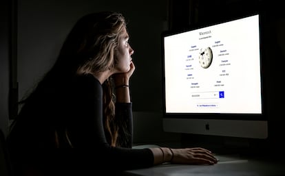 Una estudiante frente al ordenador mira una página de Wikipedia.