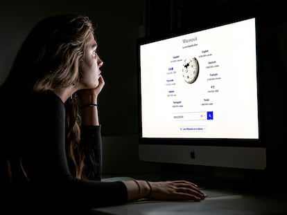 Una estudiante frente al ordenador mira una página de Wikipedia.