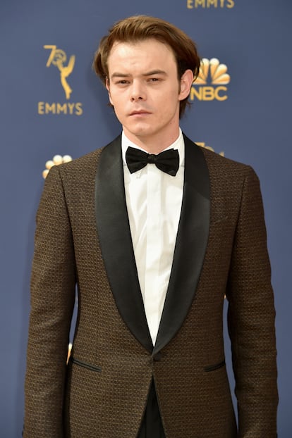 Charlie Heaton, de Stranger Things, con traje tramado que combina marrón y negro.