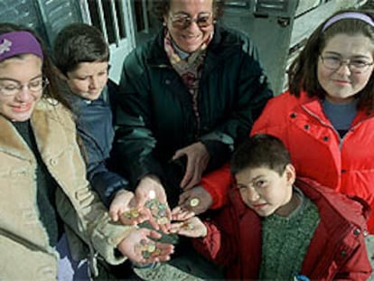 Un grupo de habitantes del municipio de La Acebeda (Madrid) muestra las diferentes monedas de euro.