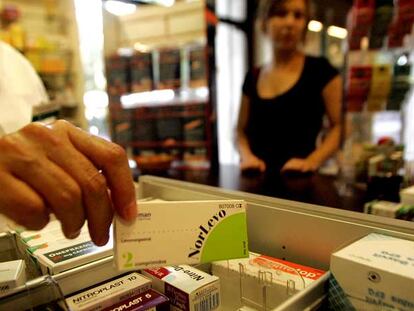 Un farmacéutico vende a una joven un envase de la píldora del día siguiente o poscoital.