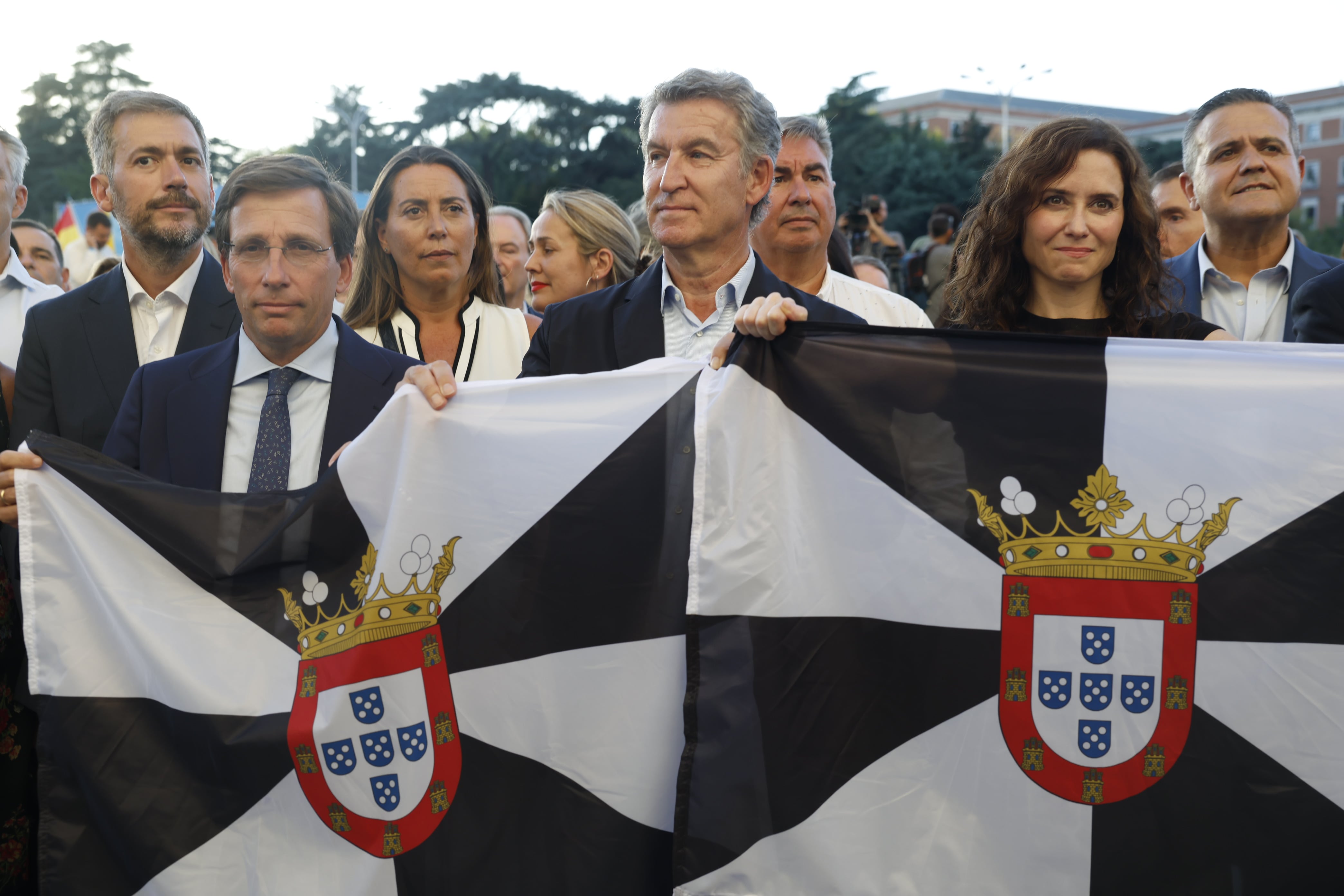 El líder del PP, Alberto Núñez Feijóo, junto al alcalde de Madrid, José Luis Martínez Almeida, y la presidenta de la Comunidad de Madrid, Isabel Díaz Ayuso, asisten a la manifestación con motivo del Día de Ceuta, este miércoles en Madrid.