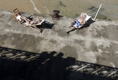 Unos bañistas toman el sol en la playa de la Concha de San Sebastián.