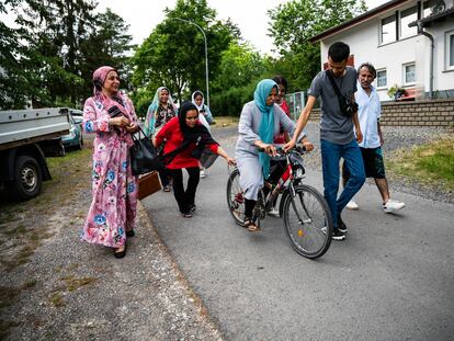 Sima Rahmati, refugiada afgana en Fulda, Alemania, intenta aprender a andar en bicicleta con la ayuda de sus hijos, adoptando así una de las costumbres occidentales.