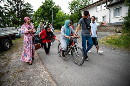 Sima Rahmati, refugiada afgana en Fulda, Alemania, intenta aprender a andar en bicicleta con la ayuda de sus hijos, adoptando así una de las costumbres occidentales.