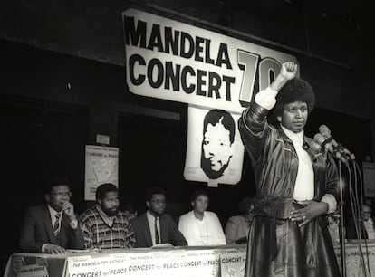 Winnie Mandela saúda com seu punho para o alto depois de anunciar um show pelo 70º aniversário de seu marido, Nelson Mandela, em 1988.