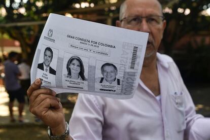 Un hombre entrega la fotocopia del tarjetón de la consulta interpartidista de la coalición de derecha durante las elecciones legislativas.